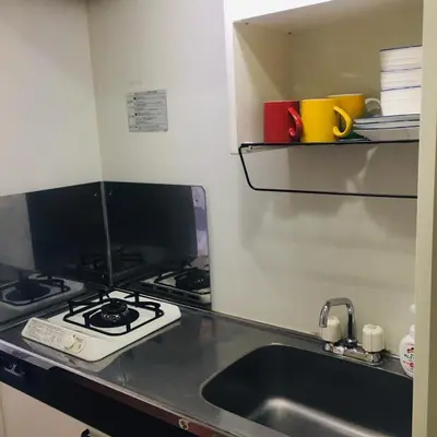 a kitchen counter with a stove and a sink at \u85e4\u548c\u30a8\u30af\u30b7\u30fc\u30eb\u9053\u7384\u5742 - \u6e0b\u8c37\u99c5\u304b\u3089\u5f92\u6b694\u5206 \u9577\u671f\u6ede\u5728\u306b\u975e\u5e38\u306b\u4fbf\u5229\u3067\u3059 in Tokyo