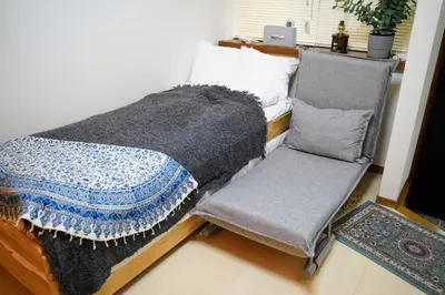 a bed and a chair in a room at Daily Hotel - \u30a8\u30af\u30bb\u30eb\u4e09\u7530 Excel Mita - \u4e09\u7530\u99c5\u304b\u3089\u5f92\u6b695\u5206 in Tokyo