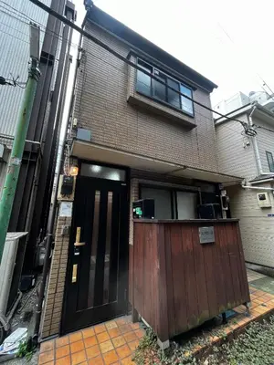 a house with a brown door and a building at Daily Hotel - \u30a8\u30af\u30bb\u30eb\u4e09\u7530 Excel Mita - \u4e09\u7530\u99c5\u304b\u3089\u5f92\u6b695\u5206 in Tokyo