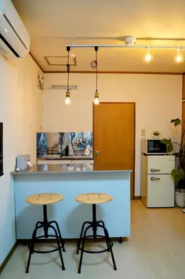 a kitchen with two tables in front of a counter at Daily Hotel - \u30a8\u30af\u30bb\u30eb\u4e09\u7530 Excel Mita - \u4e09\u7530\u99c5\u304b\u3089\u5f92\u6b695\u5206 in Tokyo