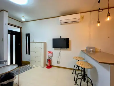 a room with a kitchen with a refrigerator and stools at Daily Hotel - \u30a8\u30af\u30bb\u30eb\u4e09\u7530 Excel Mita - \u4e09\u7530\u99c5\u304b\u3089\u5f92\u6b695\u5206 in Tokyo