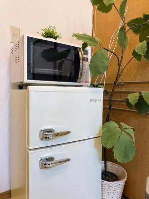 a microwave sitting on top of a refrigerator at Daily Hotel - \u30a8\u30af\u30bb\u30eb\u4e09\u7530 Excel Mita - \u4e09\u7530\u99c5\u304b\u3089\u5f92\u6b695\u5206 in Tokyo