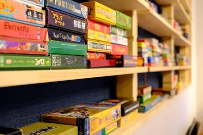 a stack of books on a shelf in a bookstore at Board Game House Tokyo - Authentic Old Tokyo - 3 BR House - 15mins to Asakusa, Skytree in Tokyo