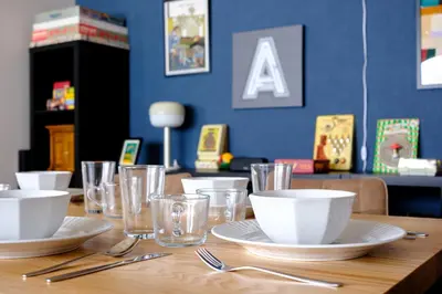 a wooden table with plates and bowls and glasses at Board Game House Tokyo - Authentic Old Tokyo - 3 BR House - 15mins to Asakusa, Skytree in Tokyo