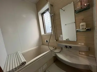 a bathroom with a sink and a tub and a mirror at Saitore in Tokyo