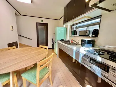 a kitchen with a wooden table and a counter top at Saitore in Tokyo