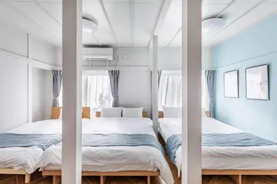 two beds in a bedroom with blue walls at AKEBONOBASHI Detached house HA1 in Tokyo