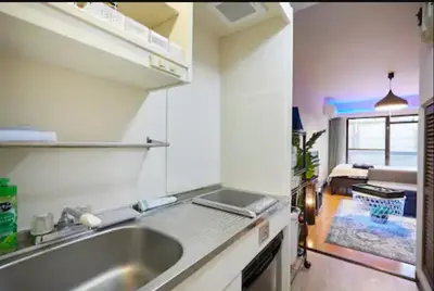 a kitchen with a sink and a room with a bed at \u65b0\u5927\u4e45\u4fdd\u30db\u30c6\u30eb\u30d7\u30ec\u30b7\u30a7\u30fc\u30c9 in Tokyo