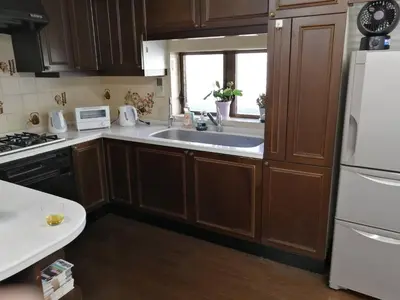 a kitchen with wooden cabinets and a sink and a window at \u30b2\u30b9\u30c8\u30cf\u30a6\u30b9\u6804 in Tokyo