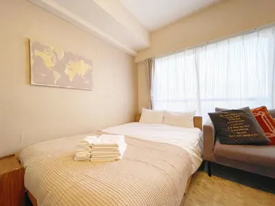 two beds in a small room with a window at LVB Shinjuku in Tokyo