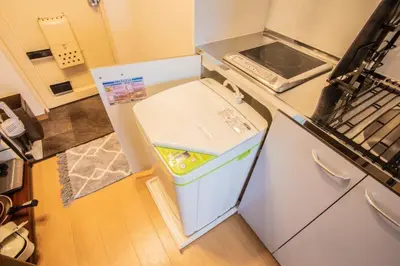a small white refrigerator with its door open in a kitchen at LVB Shinjuku in Tokyo