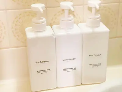 four white bottles of soap on a bathroom sink at LVB Shinjuku in Tokyo