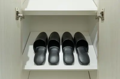 a row of black shoes sitting on a shelf at MATSUMIZAKA Hill by Tranova in Tokyo