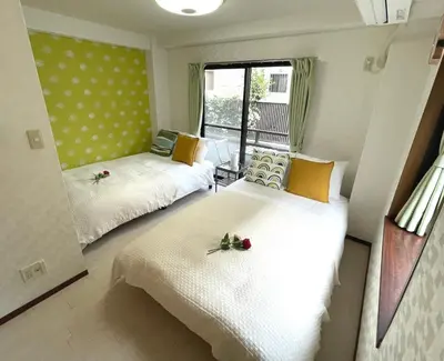two beds in a small room with a window at Near\u65b0\u5bbf Safy Room in Tokyo