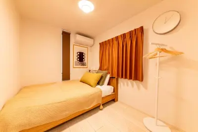 a bedroom with a bed and a clock on the wall at HOTEL Peerson - Vacation STAY 73421v in Tokyo