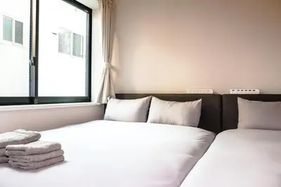 two beds in a room with a window at Seirai Asakusa Vacation Rental - Vacation STAY 81001v in Tokyo