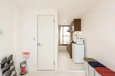 a white kitchen with a refrigerator and a door at Masaya setagaya in Tokyo