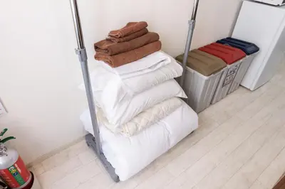 a pile of towels are stacked on a shelf in a room at Masaya setagaya in Tokyo