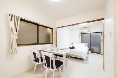 a white room with a table and chairs and a bed at Masaya setagaya in Tokyo