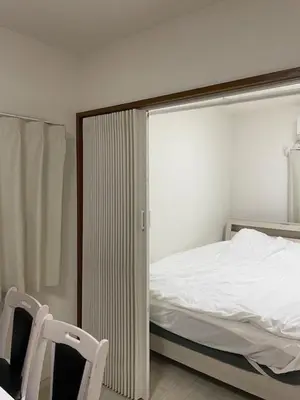 a small bedroom with a bed and a chair at Masaya setagaya in Tokyo
