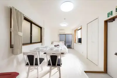 a white dining room with a table and chairs at Masaya setagaya in Tokyo