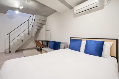 a bedroom with a large bed and a staircase at Lega land\u5e61\u30f6\u8c37ANNEX in Tokyo