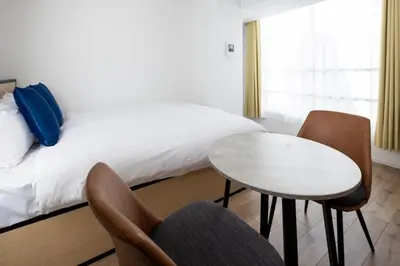 a bedroom with a bed and a table and chairs at Lega land\u5e61\u30f6\u8c37ANNEX in Tokyo