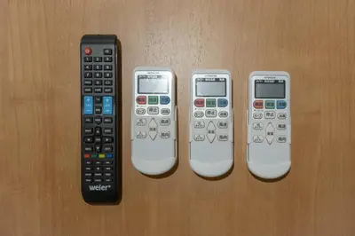 four remote controls are lined up on a table at Lega land\u5e61\u30f6\u8c37ANNEX in Tokyo