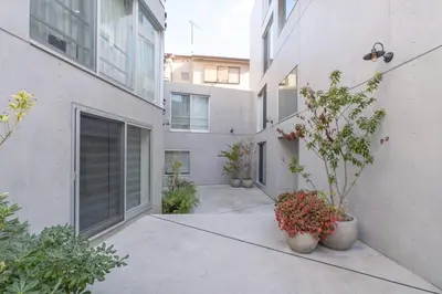 an empty courtyard of a building with potted plants at Lega land\u5e61\u30f6\u8c37ANNEX in Tokyo