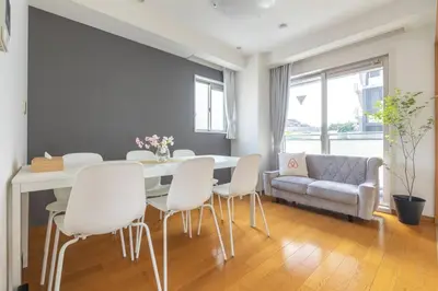 a dining room with a table and white chairs at SKY GATE Azabu in Tokyo