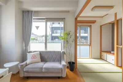 a living room with a couch and a large window at SKY GATE Azabu in Tokyo