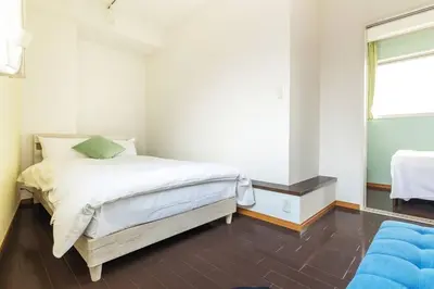 a bedroom with a bed with white sheets and a window at SKY GATE Azabu in Tokyo
