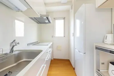 a white kitchen with a sink and a microwave at SKY GATE Azabu in Tokyo