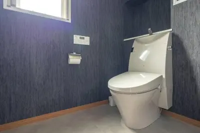 a bathroom with a white toilet in a purple wall at SKY GATE Azabu in Tokyo
