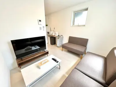 a living room with a flat screen tv and a chair at \u4e00\u68df3\u623f\u5225\u5885 \u76f4\u9054\u4e0a\u91ce3\u5206 \u5bb9\u7d0d6\u4eba \u8eca\u7ad9\u8d70\u8def4\u5206 in Tokyo