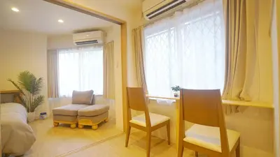 a bedroom with a bed and a chair and a window at TOKYO AKATSUKI HOTEL in Tokyo