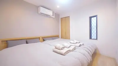 a bedroom with a white bed with towels on it at TOKYO AKATSUKI HOTEL in Tokyo