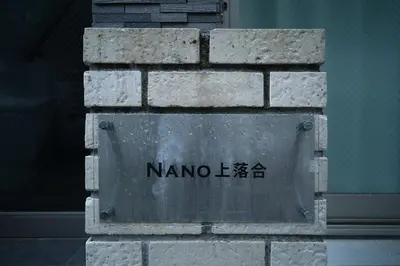 a sign on the side of a brick wall at Nano Kamiochiai by Tranova in Tokyo