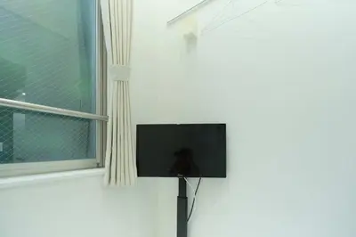 a flat screen tv on a wall next to a window at Nano Kamiochiai by Tranova in Tokyo