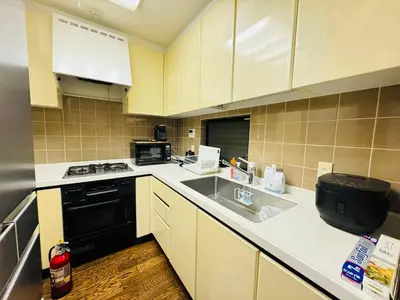a small kitchen with a sink and a stove at Hanegi House -SE0417 in Tokyo