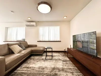 a living room with a couch and a flat screen tv at Hanegi House -SE0417 in Tokyo
