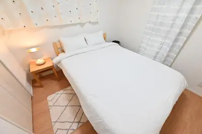 a small bedroom with a white bed and a table at 小春日和-東新宿獨立包棟/車站3分鐘＿玥澄館 in Tokyo