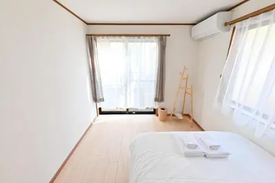 a bedroom with a white bed and a window at Private Villa Sinjuku -7min to \u9ad8\u7530\u99ac\u5834\u99c5 in Tokyo
