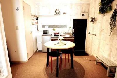 a small kitchen with a table and two chairs at \u30a2\u30f3\u30c9\u30b9\u30c6\u30a4\u5e61\u30f6\u8c37202 in Tokyo