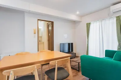 a living room with a wooden table and a blue couch at LT Shinjuku West in Tokyo