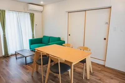 a living room with a table and a green couch at LT Shinjuku West in Tokyo
