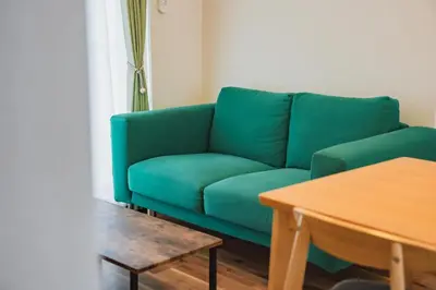 a green couch in a living room with a table at LT Shinjuku West in Tokyo