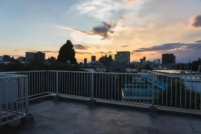 a balcony with a view of a city at sunset at LT Shinjuku West in Tokyo