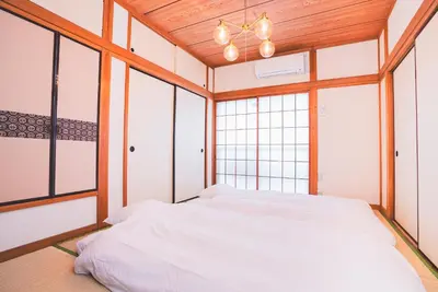 a bedroom with a bed in a room with windows at New! Kamata close Haneda AP - Traditional & Hot Spring in Tokyo