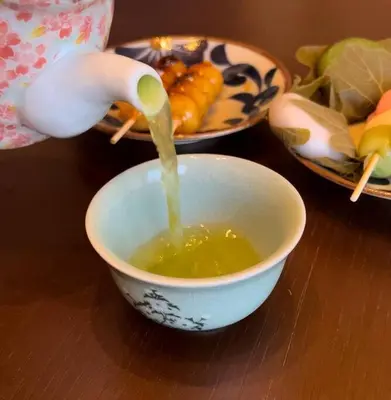 a person pouring soup into a bowl on a table at New! Kamata close Haneda AP - Traditional & Hot Spring in Tokyo